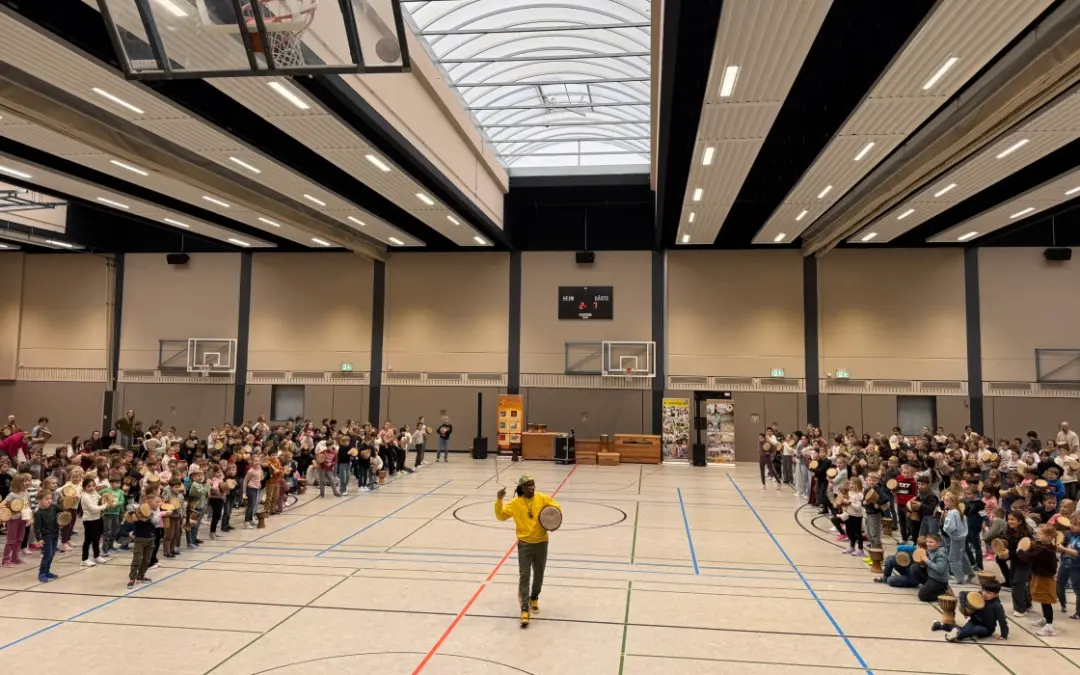 Gemeinsames Trommeln von Kindern und Eltern in der Turnhalle