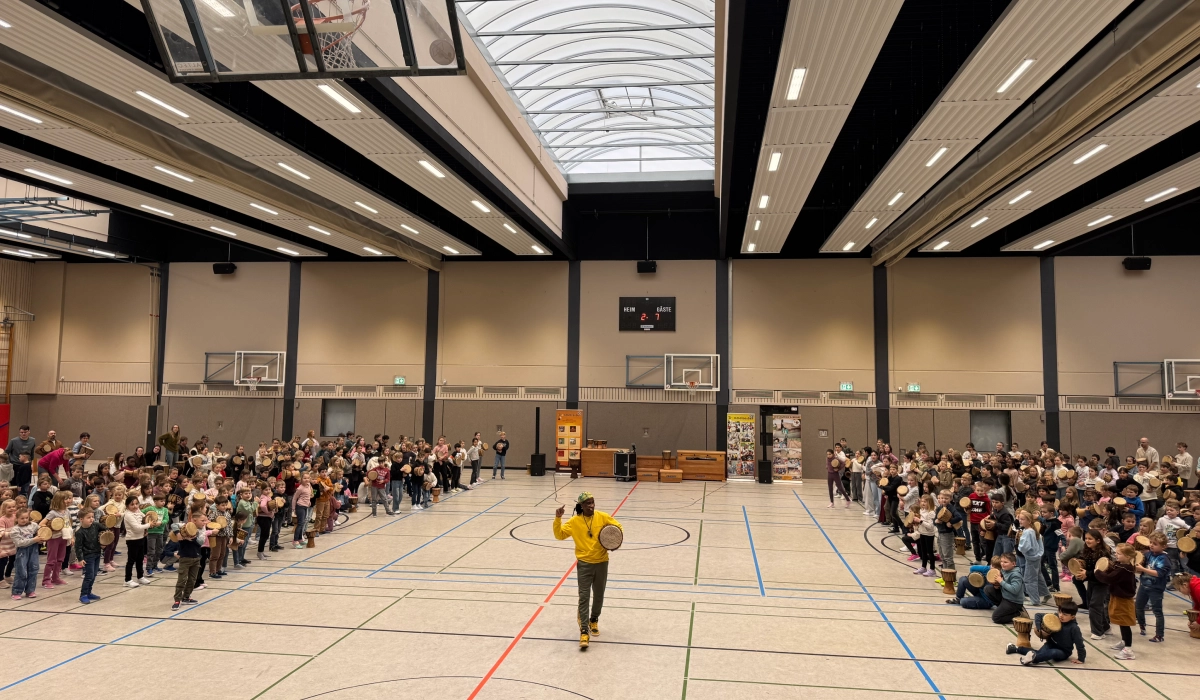 Gemeinsames Trommeln von Kindern und Eltern in der Turnhalle